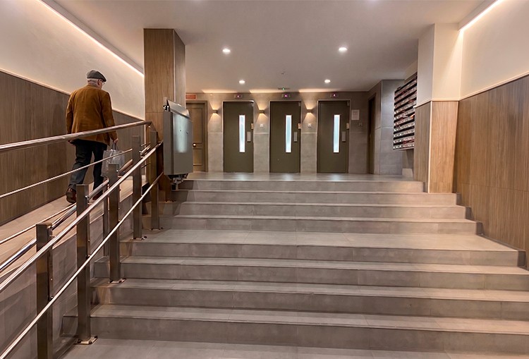 Differences between a home lift and a conventional lift 3 Elderly man on a balcony with a low-speed home lift compliant with the Machinery Directive for houses